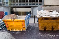 Skip full of rubbish outside an office building. Photo via SHUTTERSTOCK