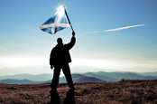man and scottish flag photo via Shutterstock