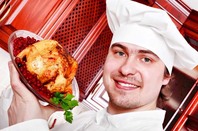 chef presents a roast chicken in pomegranate sauce. Photo by Shutterstock