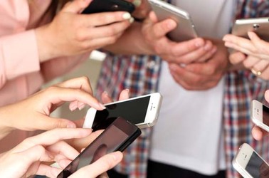 Young "creatives" whip out their mobile phones. Photo by Shutterstock