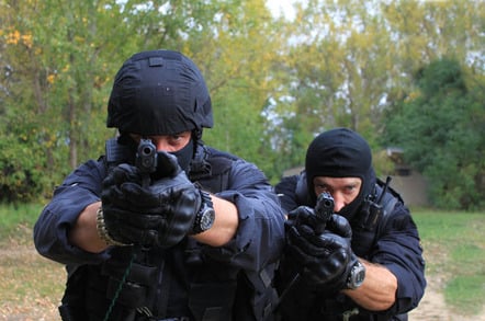Cops with guns, image via Shutterstock