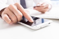Closeup of man's hands holding credit cards and using mobile phone. Pic vis SHutterstock