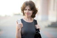 Woman frustrated while trying to make mobile phone call... Photo via Shutterstock