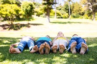 Children playing outside, lie barefoot on grass. Photo by Shutterstock