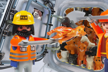 Two workers shovelling cats into the podule