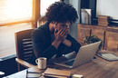 Embarrassed/exhausted man sits in front of laptop in hipstery office. Photo by Shutterstock