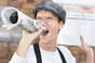 Man shouting the news from a rolled up newspaper