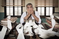 Frustrated accountant puts head in hands. Photo by Shutterstock