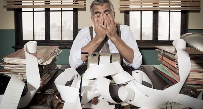 Frustrated accountant puts head in hands. Photo by Shutterstock