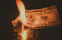 Burning money, photo via Shutterstock