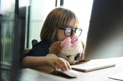 Girl and computer, photo via Shutterstock