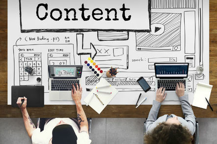 Two designers sitting in front of a "conceptual" desk filled with buzzwords. Photo by Shutterstock