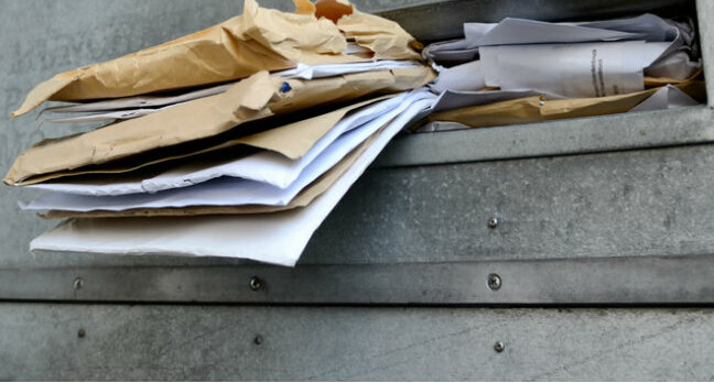 letters stuffed in a mailbox. Photo by SHutterstock