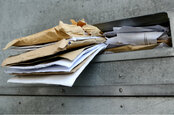 letters stuffed in a mailbox. Photo by SHutterstock