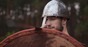 Man in helmet looks uncertain, holds up shield. Photo by Shutterstock