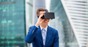 Smiling man wears VR headset against backdrop of city. Photo by Shutterstock