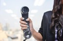 Woman holds up PBX phone in office. Pic by Shutterstock