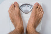 Man weighs himself on imperial scale. photo by shutterstock 