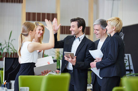 Colleague high fives in the office. Photo by Shutterstock
