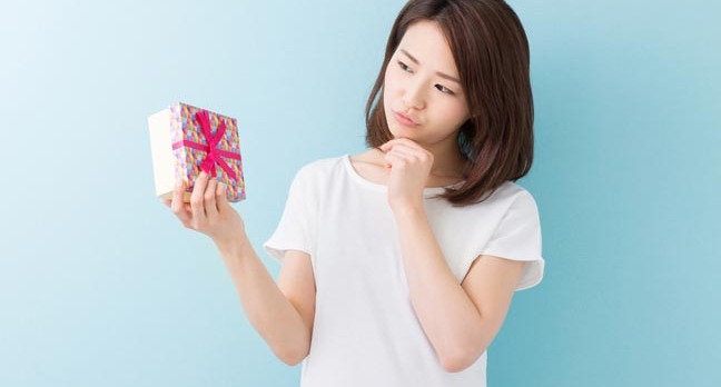 Thanks, I suppose. Woman contemplates unwanted gift. Photo by Shutterstock