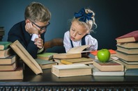 Schoolkids in uniform studying with books/apple. Photo by shutterstock