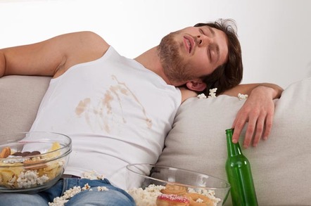 Sleeping man on couch with a beer , popcorn and a food-stained vest. Photo by Shutterstock