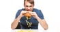 Man sloppily eats a hamburger... chips and pickle fall out. Photo by Shutterstock