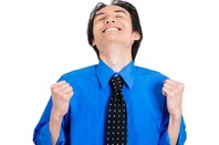 Man in blue shirt and tie raises face to the sky in bliss during double fist-pump. Photo by Shutterstock