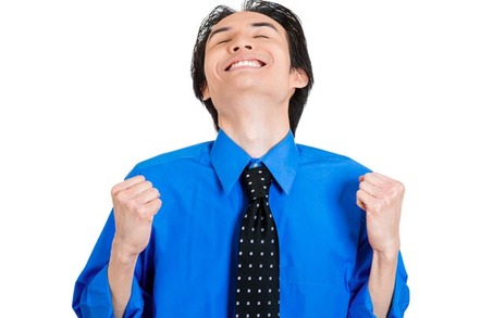 Man in blue shirt and tie raises face to the sky in bliss during double fist-pump. Photo by Shutterstock