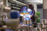 Worker welds at manufacturing plant. Phto by Shutterstock