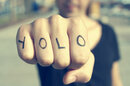 Man with YOLO tattooed on his knuckles prepares to punch the viewer (of the pic). Photo by Shutterstock