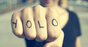 Man with YOLO tattooed on his knuckles prepares to punch the viewer (of the pic). Photo by Shutterstock