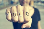 Man with YOLO tattooed on his knuckles prepares to punch the viewer (of the pic). Photo by Shutterstock