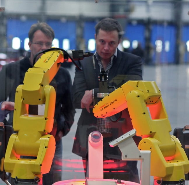 The yellow robot arms dance through an assembly demo for Elon Musk and the rest of the tour group that visited the reopening of the former NUMMI plant, now Tesla Motors. photo by Steve Jurvetson licensed under CC 2.0 must attribute