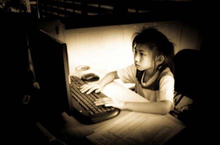 child looks downcast on a computer. Photo by Shutterstock