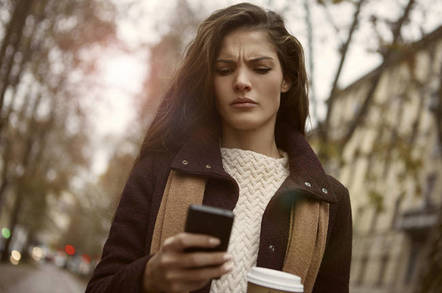 An angry woman looking at her phone