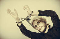 A man with his hands chained up