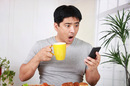 Surpised man mobile phone photo by Shutterstock