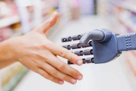 A robot and person shaking hands