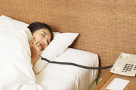 woman answers phone in the middle of the night. photo by SHutterstock