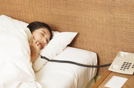 woman answers phone in the middle of the night. photo by SHutterstock