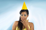 Woman looks bored wearing birthday hat. Photo by Shutterstock