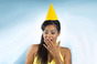 Woman looks bored wearing birthday hat. Photo by Shutterstock