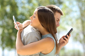Couple on phones photo via Shutterstock