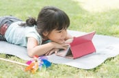 child browsing on tablet outdoors. pHOTO BY SHUTTERSTOCK