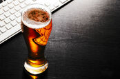 Desk beer - pint at a keyboard. Photo by shutterstock