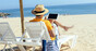 Man browses his tablet and ignores the beach. Photo by shutterstock