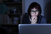 Woman stares at laptop screen, shocked. Pic by shutterstock