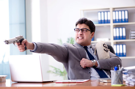 Businessman with money bag and gun photo via Shutterstock