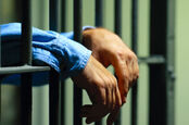 hands through the jail bars. Photo by shutterstock